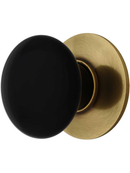 1 3/8 inch Black Porcelain Cabinet Knob With Brass Rosette in Antique Brass.